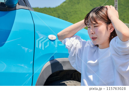 車の前で頭を抱える女性　パンク　トラブル 115763028