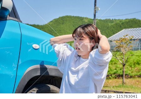 車の前で頭を抱える女性　パンク　トラブル 115763041