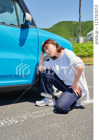 車の前で頭を抱える女性　パンク　トラブル 115763053