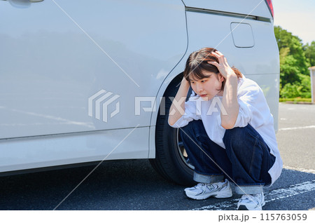 車の前で頭を抱える女性　パンク　トラブル 115763059