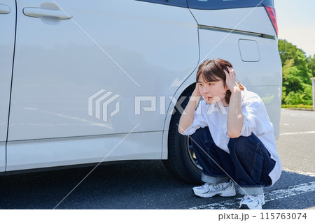 車の前で頭を抱える女性　パンク　トラブル 115763074