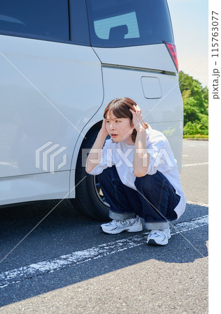 車の前で頭を抱える女性 パンク トラブル 車の前で頭を抱える女性 パンク トラブル 115763077