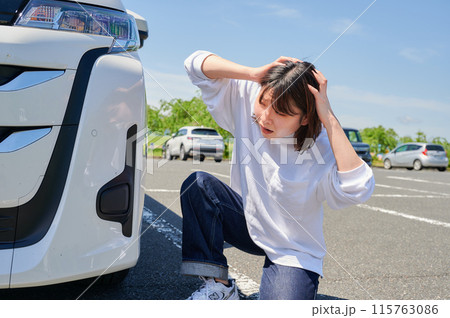 車の前で頭を抱える女性　パンク　トラブル 115763086