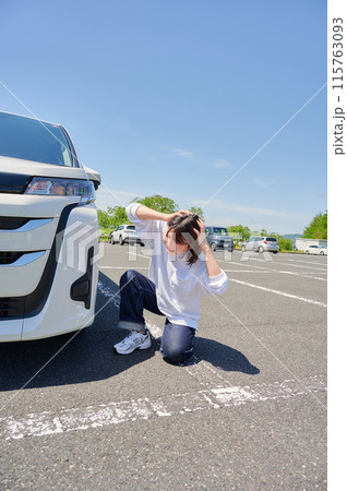 車の前で頭を抱える女性 パンク トラブル 車の前で頭を抱える女性 パンク トラブル 115763093
