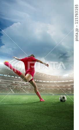 Vertical image of woman, soccer player in red uniform during match hitting ball, scoring goal. 3D render of stadium with fans tribune 115763193