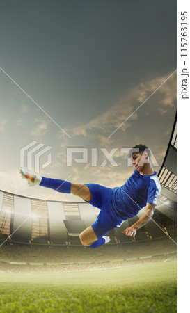 Vertical image of young guy, soccer player in blue uniform in motion, hitting ball with dynamics and focus, playing. 3D render of stadium 115763195