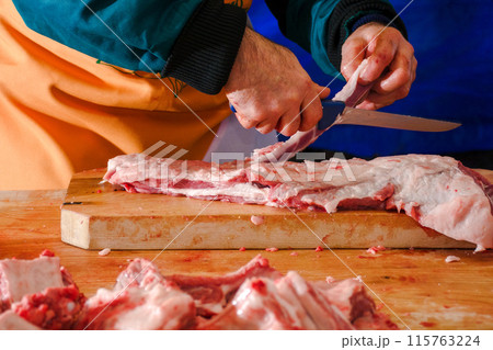 cutting flesh on the wooden board. process of preparing meat for traditional hungarian bogracs goulash soup. pork butchers competition 115763224