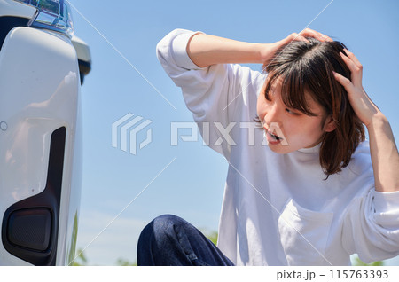 車の前で頭を抱える女性　パンク　トラブル 115763393