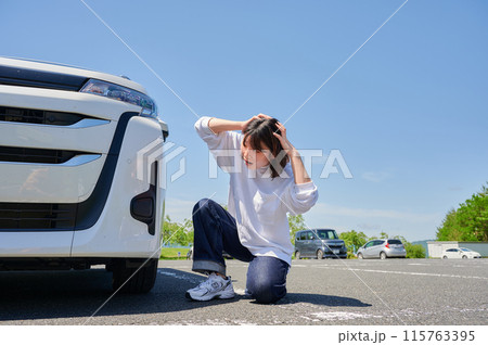 車の前で頭を抱える女性　パンク　トラブル 115763395