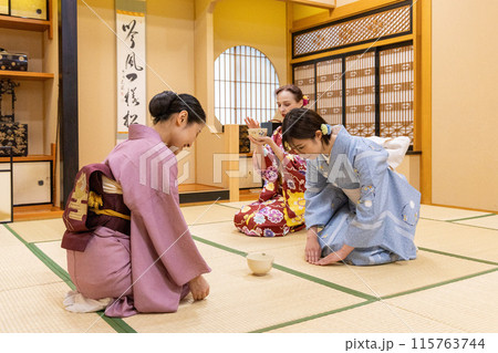 茶道体験をする着物姿の外国人女性観光客と案内役の日本人女性 茶道体験をする着物姿の外国人女性観光客と案内役の日本人女性 115763744
