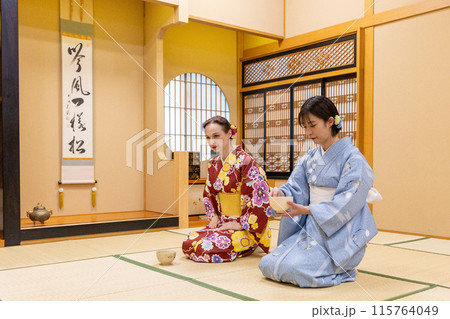 茶道体験を楽しむ着物姿の外国人女性観光客と日本人女性 115764049