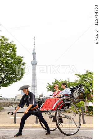 スカイツリーを背景に人力車に乗る着物姿の外国人女性と日本人女性 スカイツリーを背景に人力車に乗る着物姿の外国人女性と日本人女性 115764553