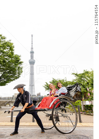 スカイツリーを背景に人力車に乗る着物姿の外国人女性と日本人女性 スカイツリーを背景に人力車に乗る着物姿の外国人女性と日本人女性 115764554