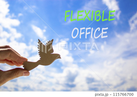 Flexible office symbol. Concept words Flexible office on beautiful sky. Beautiful blue sky cloud background. Businessman hand with wooden bird. Business Flexible office concept. Copy space. Flexible office symbol. Concept words Flexible office on beautiful sky. Beautiful blue sky cloud background. Businessman hand with wooden bird. Business Flexible office concept. Copy space. 115766700