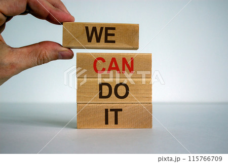 Male hand placing a blocks with word 'we' on top of a blocks tower. Text 'can do it'. Beautiful white background. Copy space. Male hand placing a blocks with word 'we' on top of a blocks tower. Text 'can do it'. Beautiful white background. Copy space. 115766709