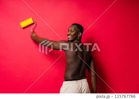 Happy construction worker holding paint roller performing interior renovation with optimism. Happy construction worker holding paint roller performing interior renovation with optimism. 115767766
