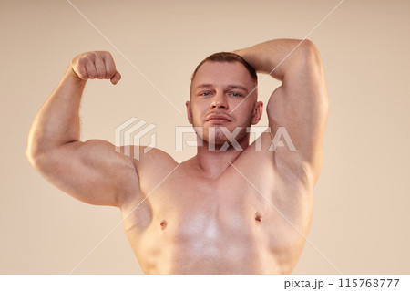 Medium shot of attractive male bodybuilder wearing no shirt in front lat and bicep pose looking at camera isolated over neutral background Medium shot of attractive male bodybuilder wearing no shirt in front lat and bicep pose looking at camera isolated over neutral background 115768777