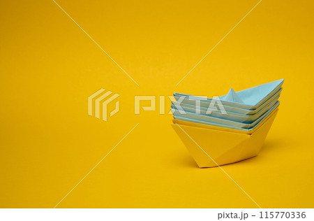 Paper boats on a yellow background Paper boats on a yellow background 115770336