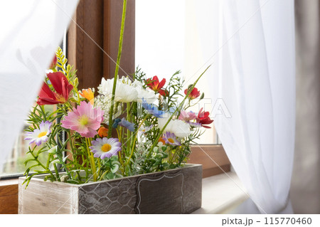 Artificial plant colorful flowers on window sill 115770460