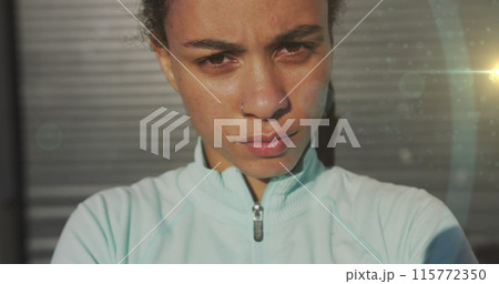 Light spot against close up of portrait of african american fit woman 115772350