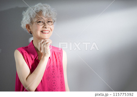 顎に手を当てて考えるグレイヘアの高齢者女性のカメラ目線のクローズアップ 115775392