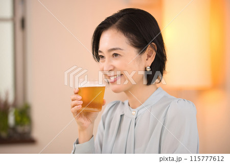 美味しそうにビールを飲むミドル女性 115777612