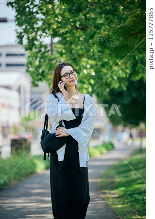 スマホで電話しながら歩く若い女性 115777865