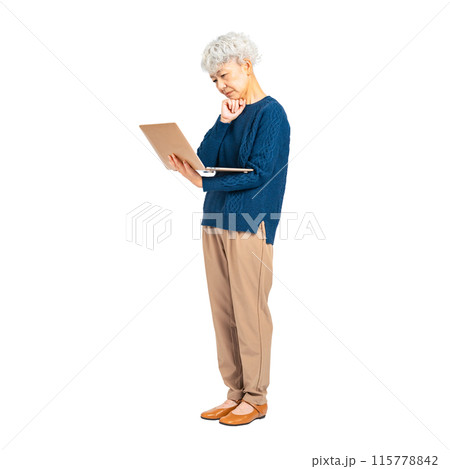 パソコンを見ながら悩むシニア女性　手作業で精密に切り抜いた背景透過全身写真PNG 115778842