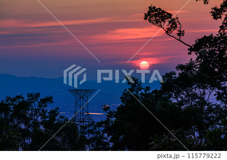奈良大阪府県境信貴生駒スカイライン海抜600m展望台夕景　中望遠ズーム　真っ赤に染めながら沈む夕日⑱ 115779222