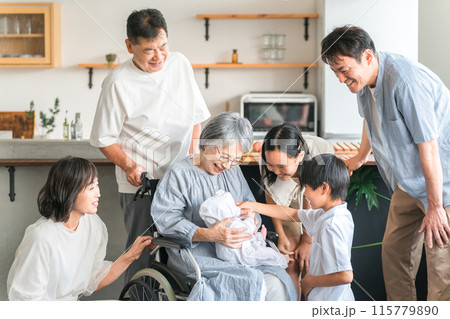赤ちゃんと対面する車椅子に乗った高齢者女性と子供達・家族 赤ちゃんと対面する車椅子に乗った高齢者女性と子供達・家族 115779890