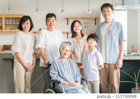 車椅子に座った高齢者女性と三世代家族 115780099