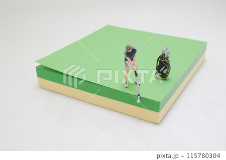 Golfer Figurine on Golf Ball on the memo pad Golfer Figurine on Golf Ball on the memo pad 115780304
