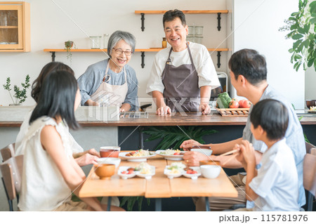 家のダイニングで家族団欒して食事する子供と夫婦・親子・三世代家族（二世帯住宅） 115781976