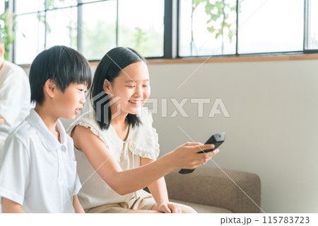 テレビ・ホームシアター・DVDのリモコンを使う子供達 テレビ・ホームシアター・DVDのリモコンを使う子供達 115783723