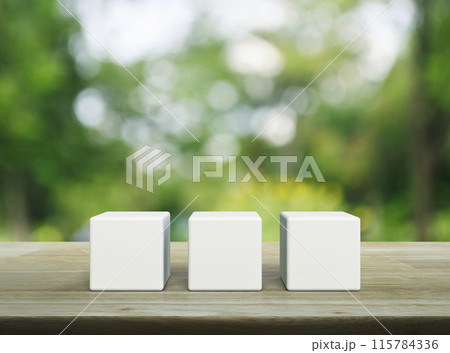Three white block cubes on wooden table 115784336