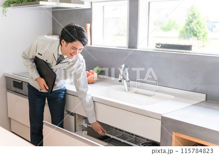 システムキッチンの収納について説明する工務店・設備会社・リフォーム業者・ビジネスマン 115784823