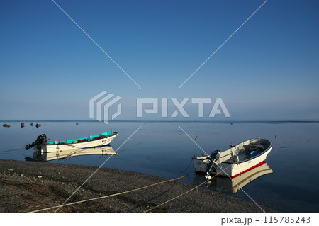 早春の日本最北端から朝凪の海に浮かぶ小型船外機付き漁船 115785243