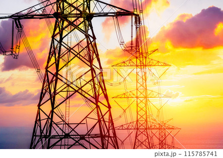 Electricity line on dusk orange sky, High voltage towers against the sunset background. Electricity line on dusk orange sky, High voltage towers against the sunset background. 115785741