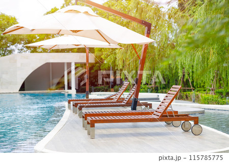 Outdoor lounge sunbeds near swimming pool, pool bed sunbath at resort hotel leisure area. Outdoor lounge sunbeds near swimming pool, pool bed sunbath at resort hotel leisure area. 115785775