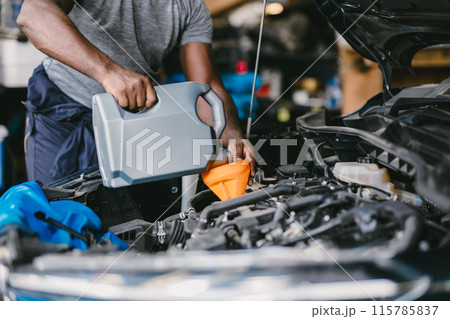 Closeup Garage Mechanic professional working car auto service engine oil filling up. 115785837