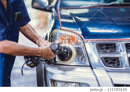 Car headlights acrylic glass cover polishing, Worker in Auto workshop using polisher machine polish coating wax in car care. 115785839