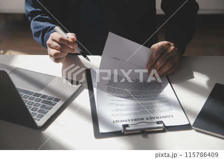 Asian businessman reviewing document reports at office workplace with computer laptop. legal expert, professional lawyer reading and checking financial documents or insurance contract Asian businessman reviewing document reports at office workplace with computer laptop. legal expert, professional lawyer reading and checking financial documents or insurance contract 115786409