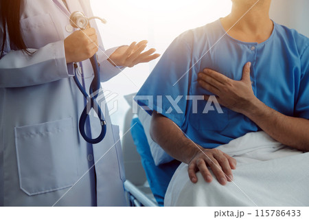 Young doctor is using a stethoscope listen to the heartbeat of the patient. Shot of a female doctor giving a male patient a check up Young doctor is using a stethoscope listen to the heartbeat of the patient. Shot of a female doctor giving a male patient a check up 115786433