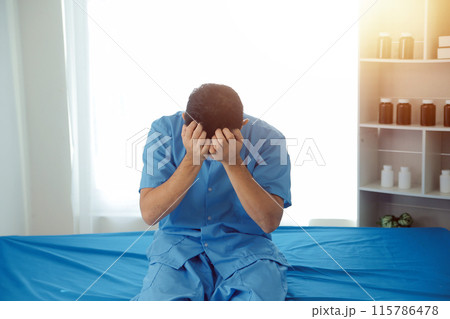 A male patient suffering from stress, migraines, eye strain, headaches, eye problems from working hard and not getting enough rest receives treatment from a doctor at the hospital. 115786478