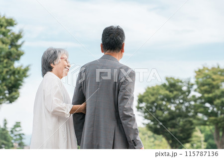 公園をを話しながら歩く日本人の高齢者夫婦（シニア・男女） 115787136