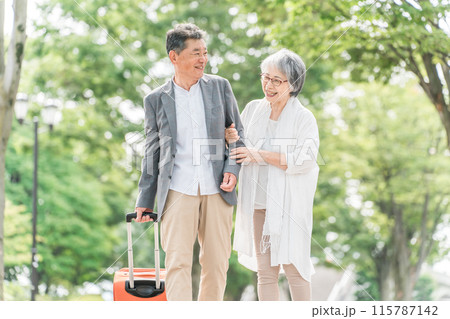 スーツケースを持って旅行する高齢者夫婦（シニアライフ・アクティブシニア） 115787142