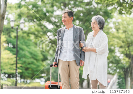スーツケースを持って旅行する高齢者夫婦（シニアライフ・アクティブシニア） 115787146