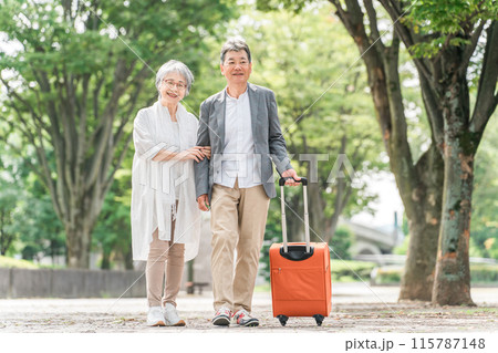 スーツケースを持って旅行する高齢者夫婦（シニアライフ・アクティブシニア） 115787148