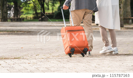 スーツケースを持って旅行する高齢者夫婦の後ろ姿（シニアライフ・アクティブシニア） 115787163