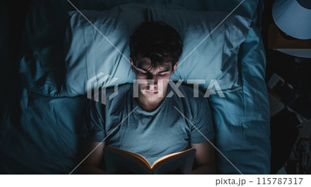 Person reading in bed at night. 115787317